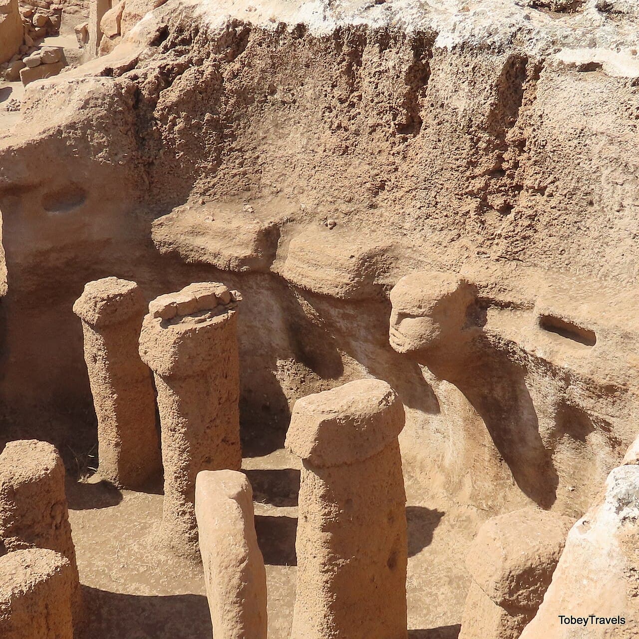 A T-shaped pillar at Göbekli Tepe with carved animals on the shaft. Fox, snake, and bull are common motifs.