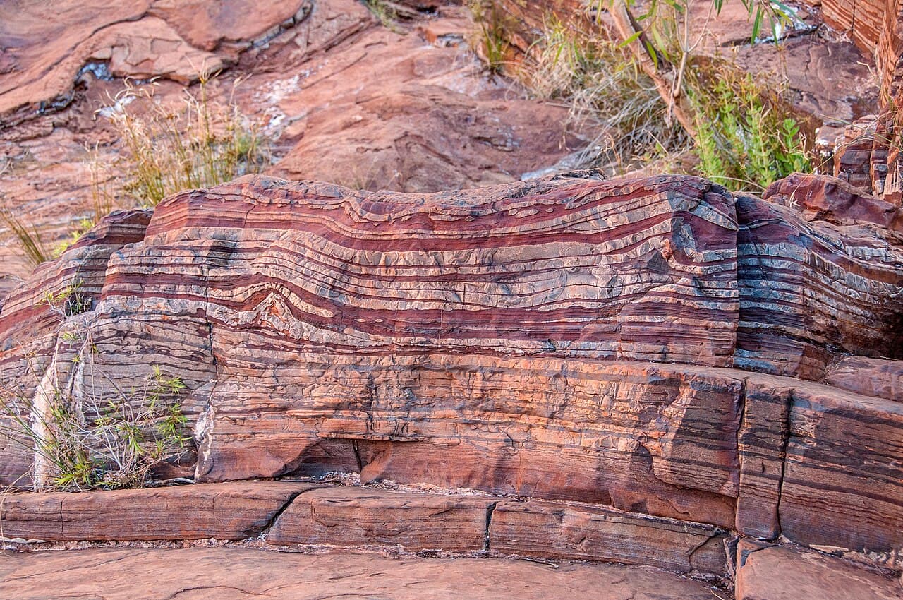 A banded iron formation in Western Australia. Each red layer is iron precipitated as oxygen began to accumulate in Earth's oceans, roughly 2.4 billion years ago.