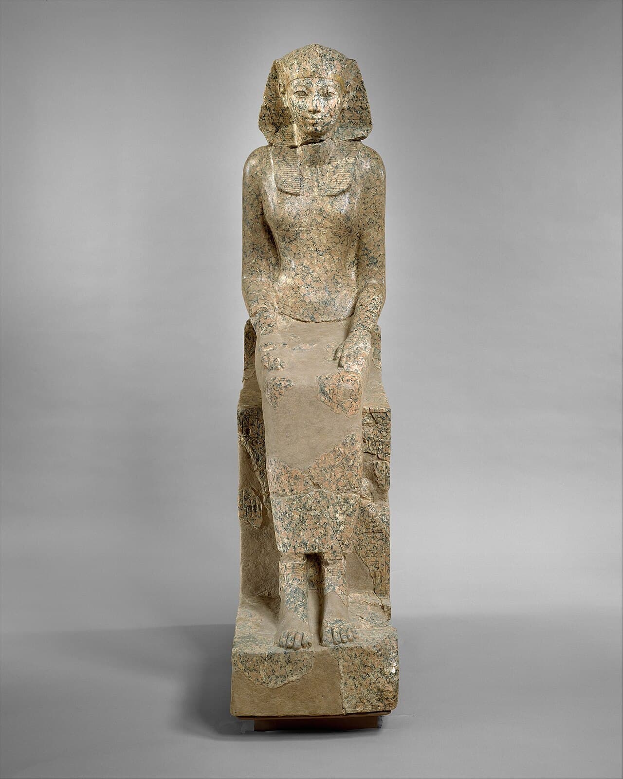 A statue of Hatshepsut in pharaonic regalia — nemes headcloth, false beard, shendyt kilt. The presentation was the institution, not a personal preference.