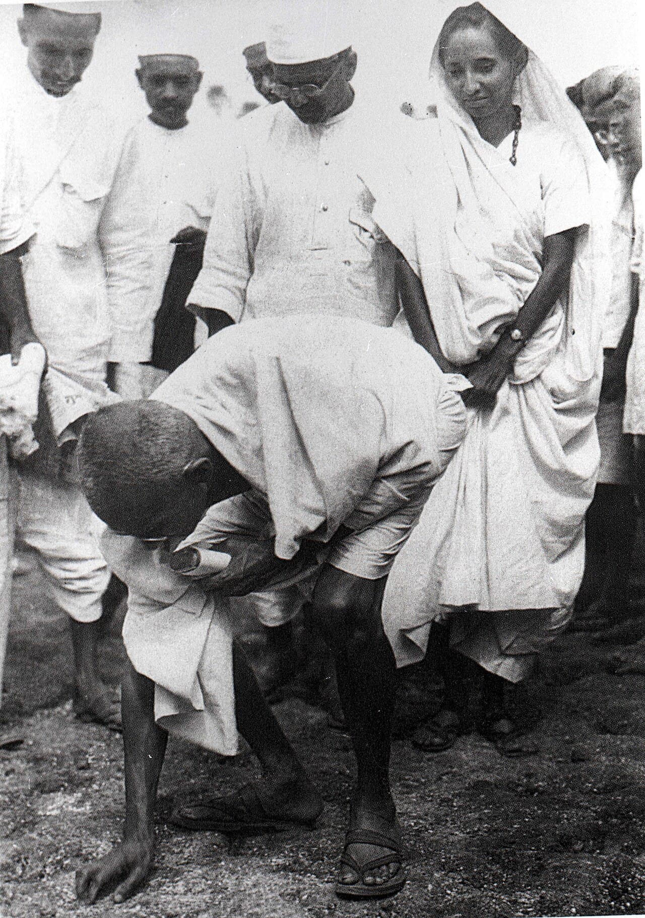 Gandhi at Dandi, 6 April 1930, picking up a handful of natural salt in violation of the British Salt Acts.